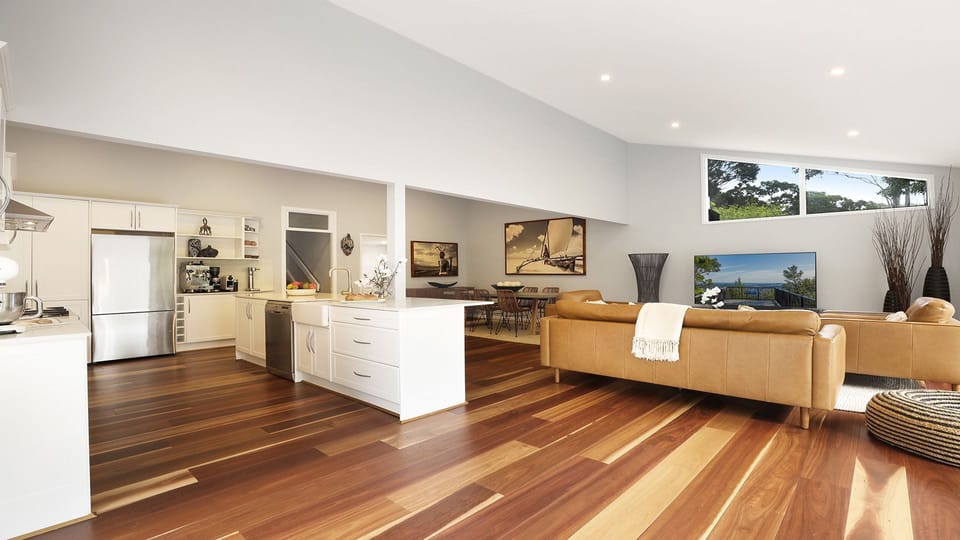 Arcadia Cottage | Living room in open plan area wth kitchen and dining | Back doors open onto beautiful uncovered deck with garden views