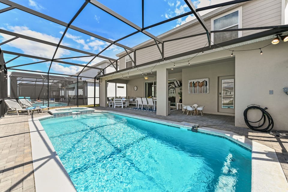 Relax by the private pool and spa with optional pool heat (additional fee), sun loungers, a dining table, comfortable couch, and a flat-screen TV.