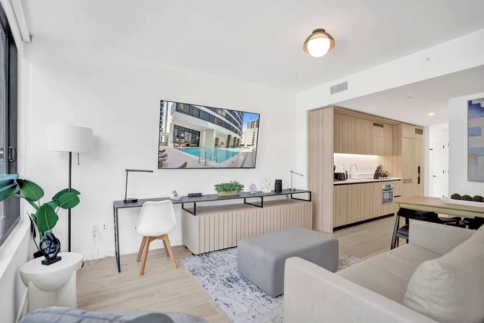 Living area with a dedicated work desk, sofa, and open pass-through to the kitchen.