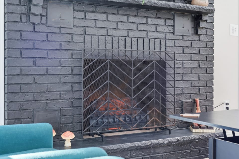 Fireplace with black brick surround and cozy ambiance