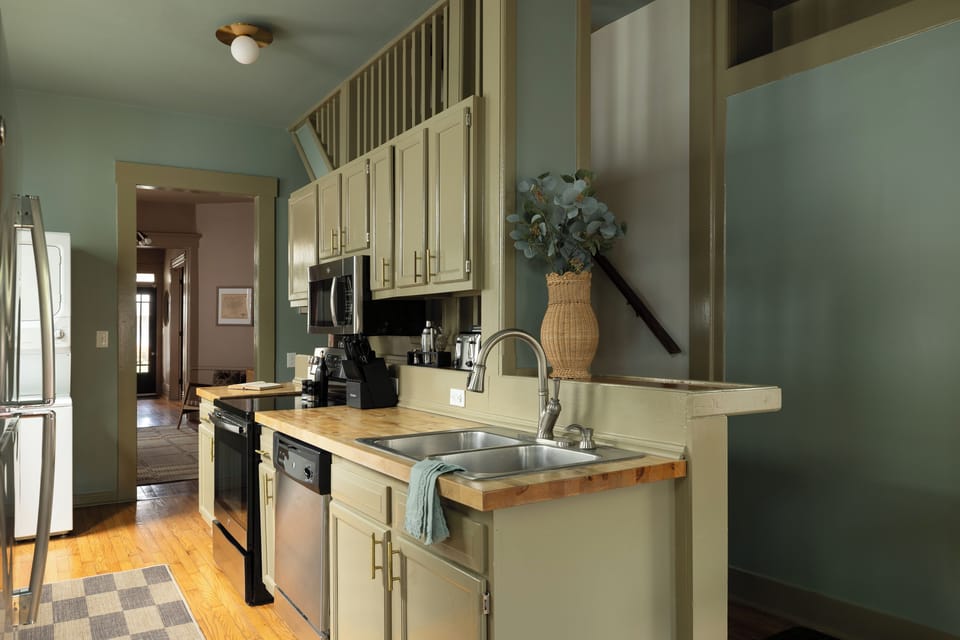 Galley Kitchen: Sage cabinets, butcher block, washer/dryer, and coffee!