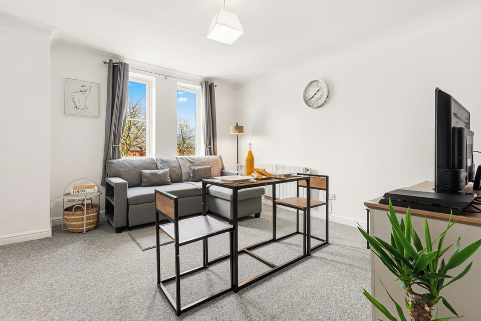 Bright and cozy lounge with sectional sofa, TV, and lots of natural light