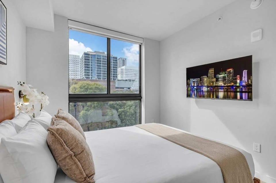 masterclass in modern comfort! This stylish bedroom features a sleek layout with expansive windows that invite the city skyline right to your bedside. Relax and recharge in a space designed for ultimate urban tranquility