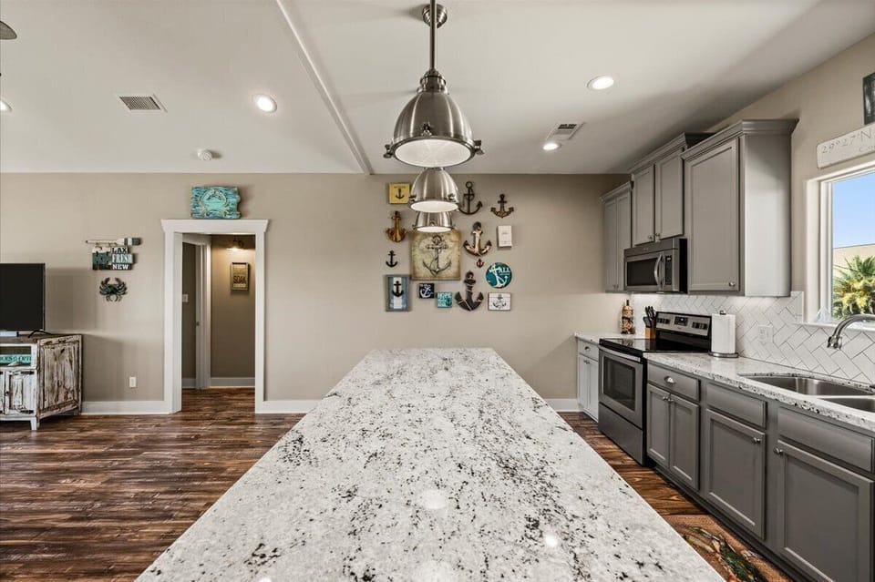 Kitchen island with granite countertops and pendant lighting – ideal for cooking and socializing.