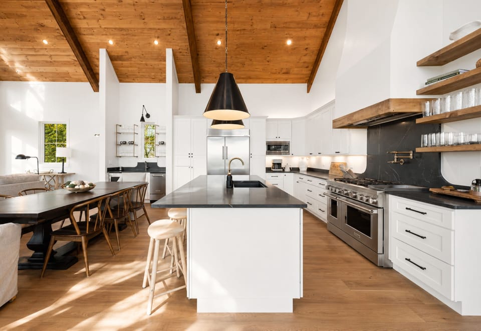 Crisp white tones meet a bold dark island and natural wood textures, a harmonious blend of modern cabin sophistication and mountain warmth.