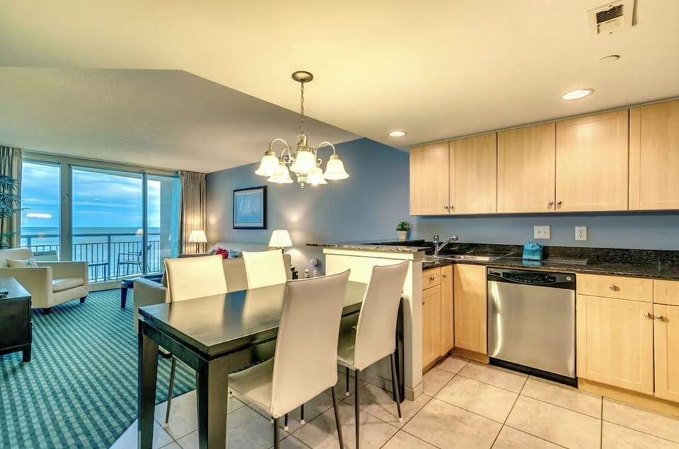 Modern dining and kitchen area with elegant flooring, sleek furniture,