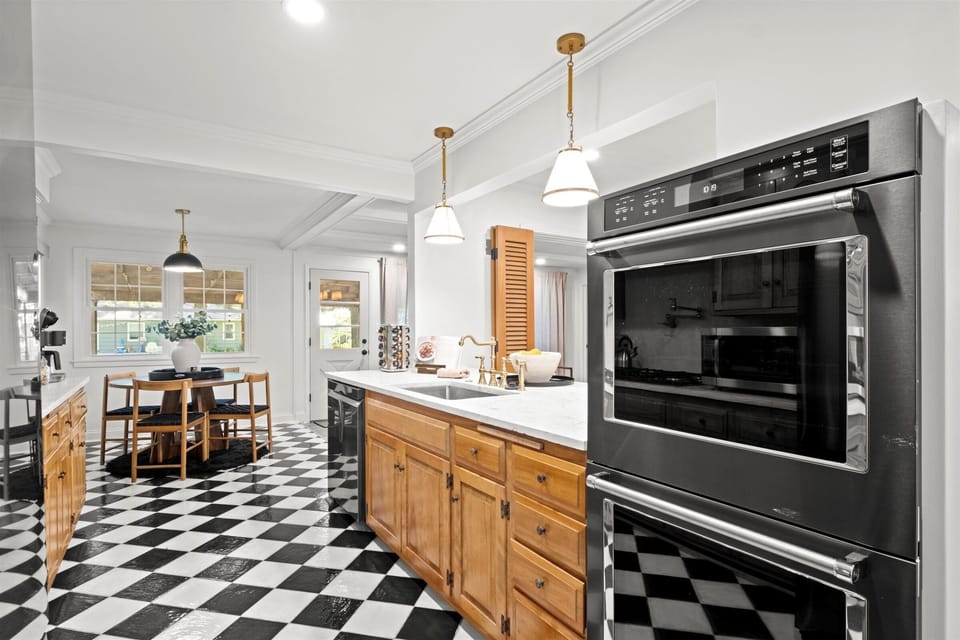 Fully equipped kitchen with double ovens, generous prep space, and adjacent dining area. Perfect for hosting group dinners in this home near Kansas City.