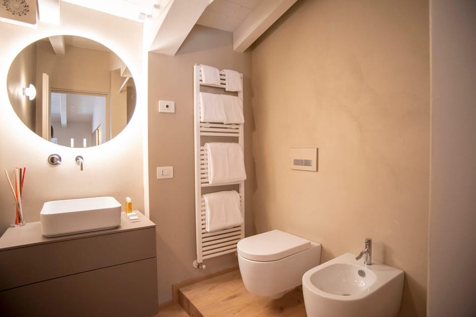Modern and functional bathroom in a studio apartment located in the center of Peschiera del Garda. The room features elegant lighting, ideal for a comfortable stay near Lake Garda.