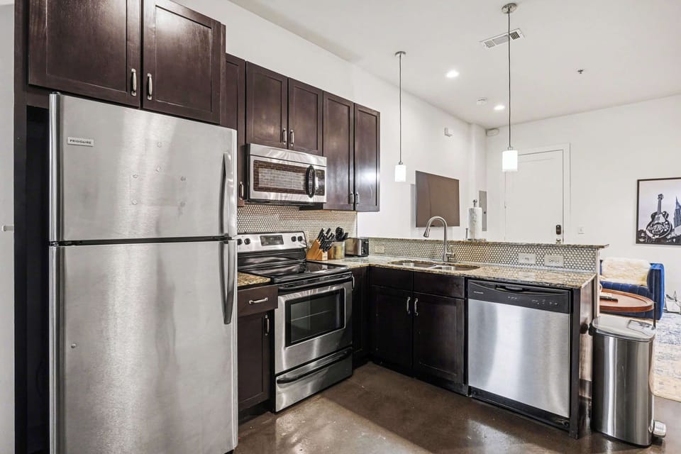 Kitchen with stainless appliances and sleek granite counters.