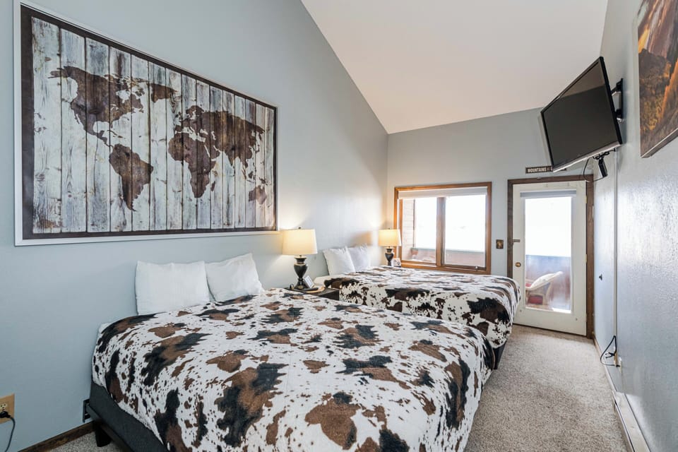 Rest easy in your comfortable lodge room at 645 SilverCreek Inn featuring queen beds, modern amenities, and a charming world map that sparks wanderlust dreams.
