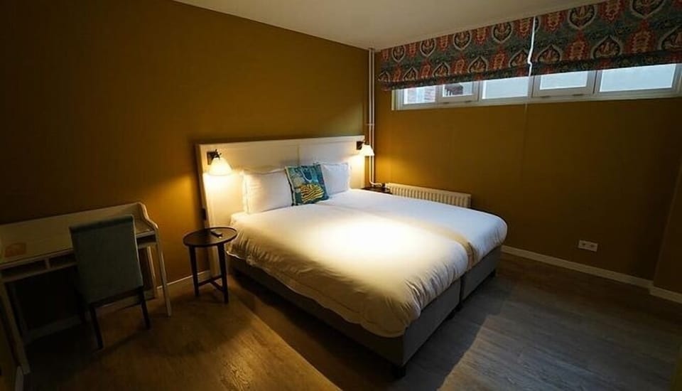 Unwind in a cozy double bed with warm lighting.
