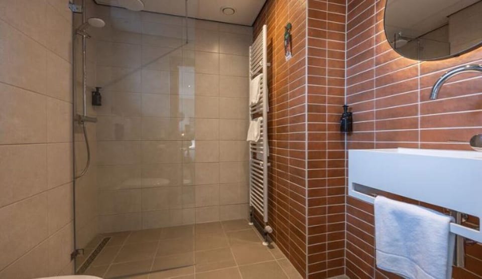 Get ready comfortably with bright vanity lighting and spacious shower.