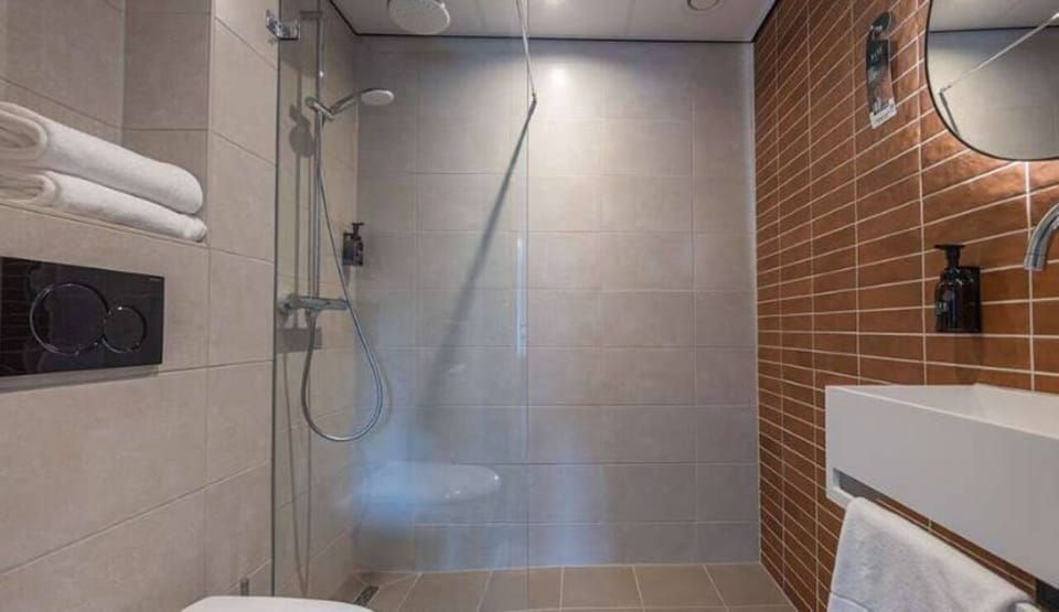 Refresh in a sleek walk-in shower with fluffy towels.