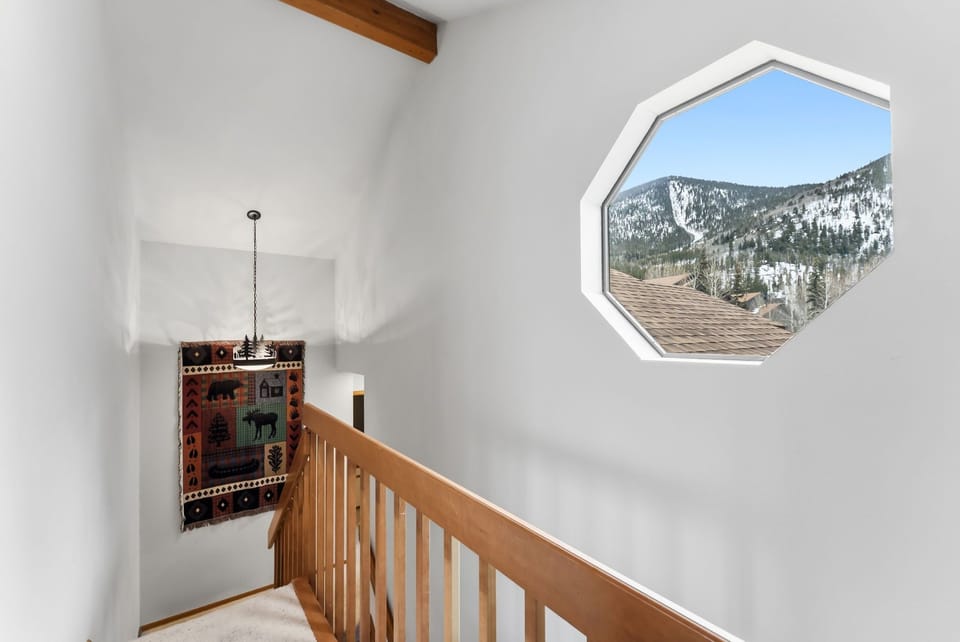Breathtaking mountain vistas greet you through this unique octagonal window, while warm wood accents create a cozy alpine atmosphere.