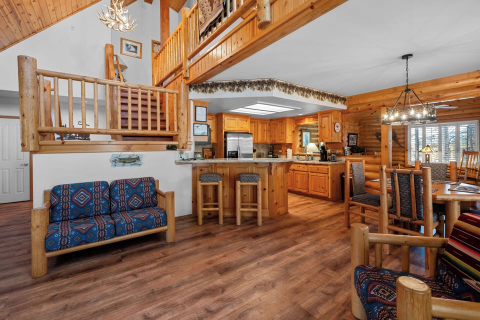 Living Room - The living space is inviting and comfortable, complete with a wood-burning fireplace, comfy seating, and vaulted ceilings.