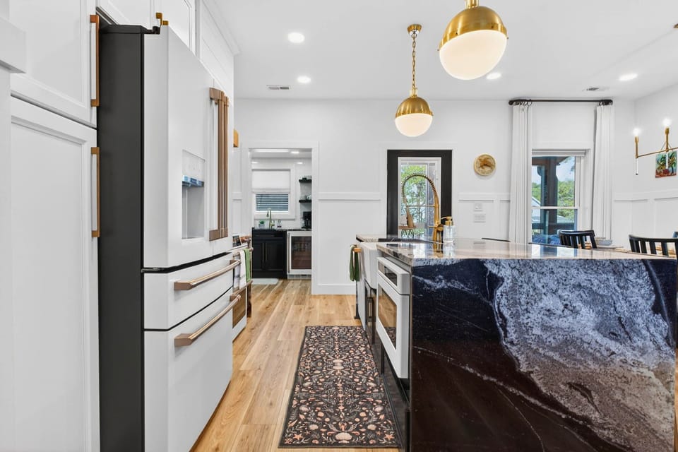 Designer kitchen featuring professional-style appliances, elegant lighting, and a spacious, functional layout.