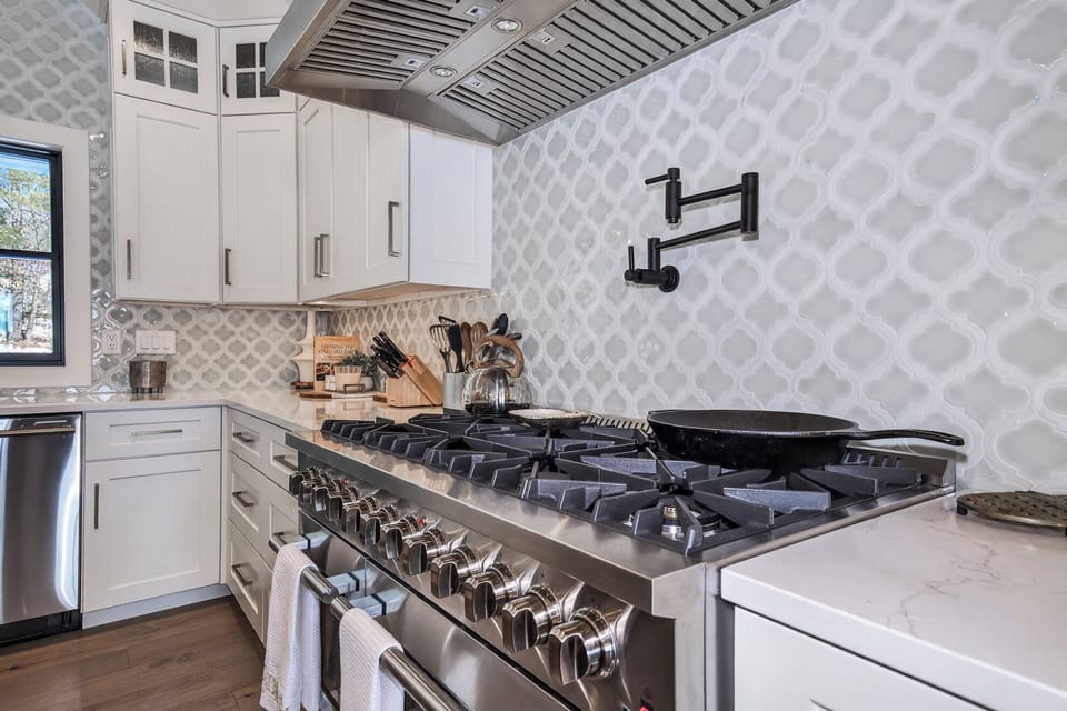 Create culinary memories in your gourmet kitchen with professional-grade appliances and elegant white cabinetry.