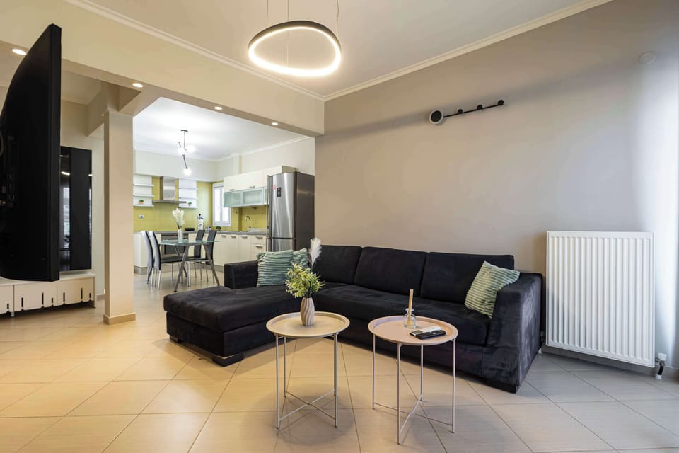 Spacious living room with large sectional sofa, modern lighting, and open layout, ideal for relaxing or socializing in comfort.