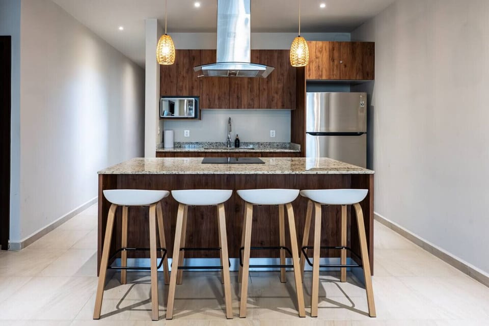 Fully equipped modern kitchen with breakfast bar, granite countertops, and stainless steel appliances.