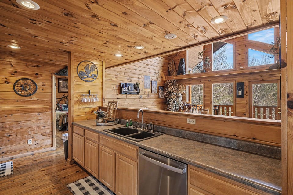 Step into your rustic cabin kitchen where warm wood surrounds you and picture windows frame nature's beauty as you cook.