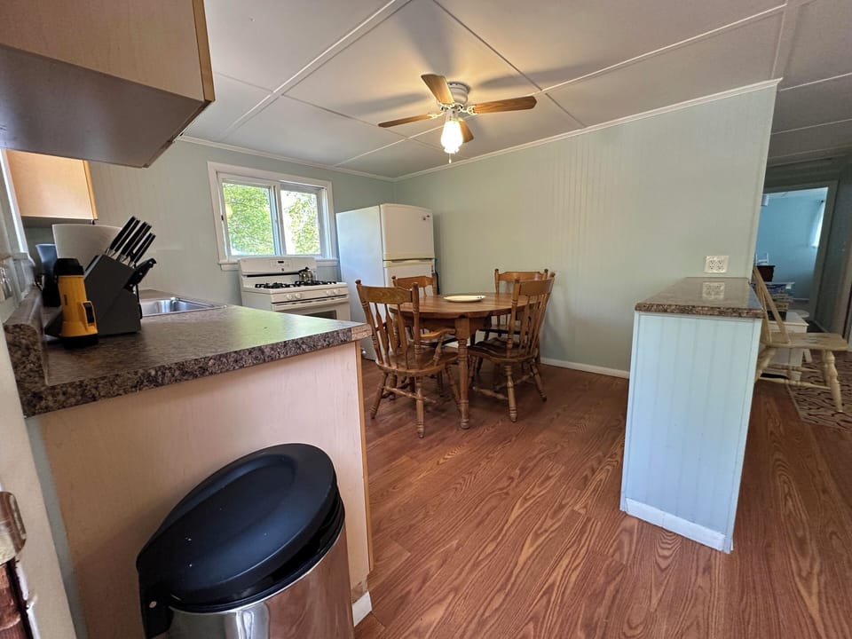 Your fully equipped kitchen flows seamlessly into the dining area, where warm wood tones and granite countertops create the perfect setting for home-cooked meals.