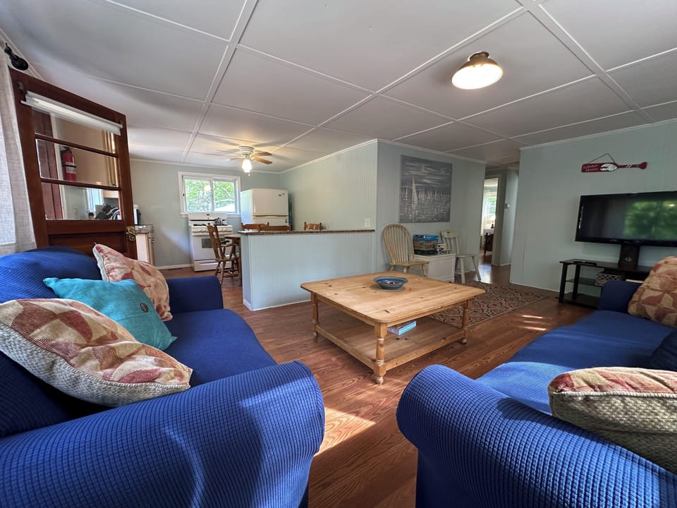 Unwind in your spacious living room with plush blue seating and open kitchen, perfect for relaxing after exploring.