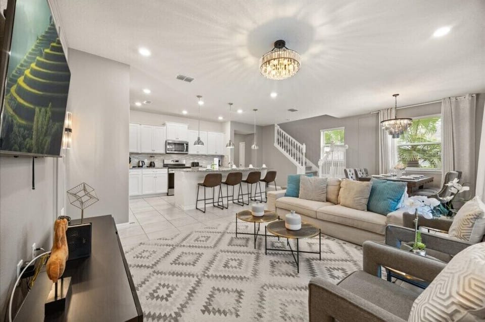 GATHERING ROOM:  Living Room Area with Sofa, 2 Chairs and 65” Flat-Screen TV with Direct Access to Lanai and Pool
