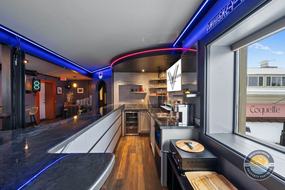 Sleek bar area with a mini fridge, coffee machine, and ample storage