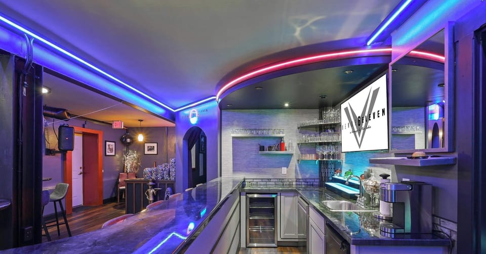 Sleek bar area with a mini fridge, coffee machine, and ample storage