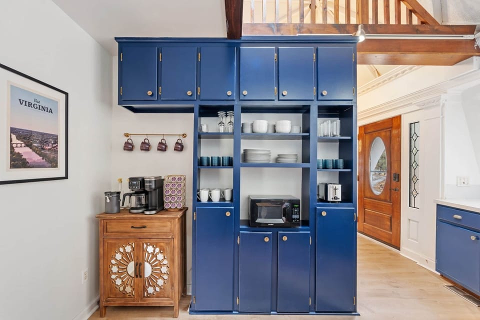 Stylish kitchen with open shelving, coffee bar, and bold blue cabinetry.