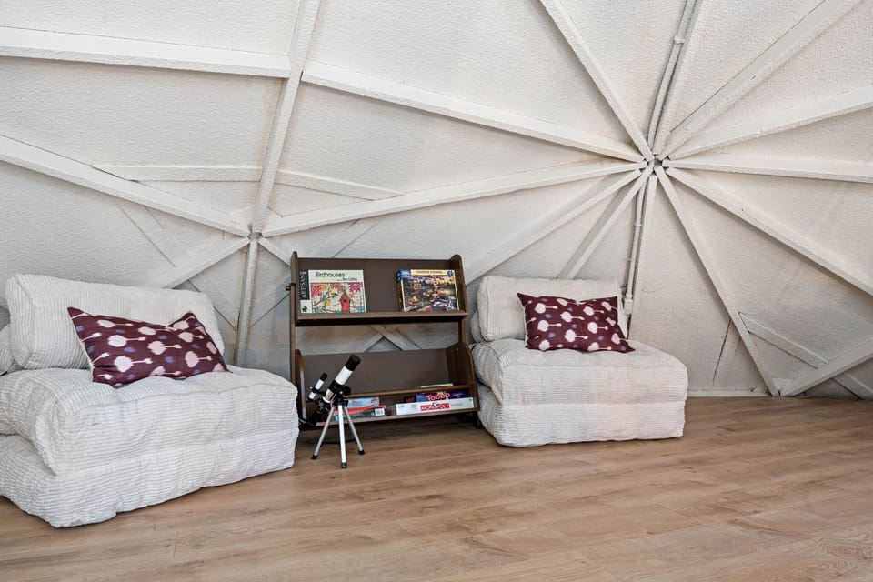 A cozy loft nook with floor seating, games, and a telescope for stargazing nights.
