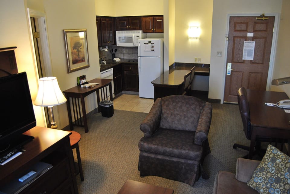 Relax in the cozy living area, featuring a comfortable chair and a flat-screen TV for your entertainment.