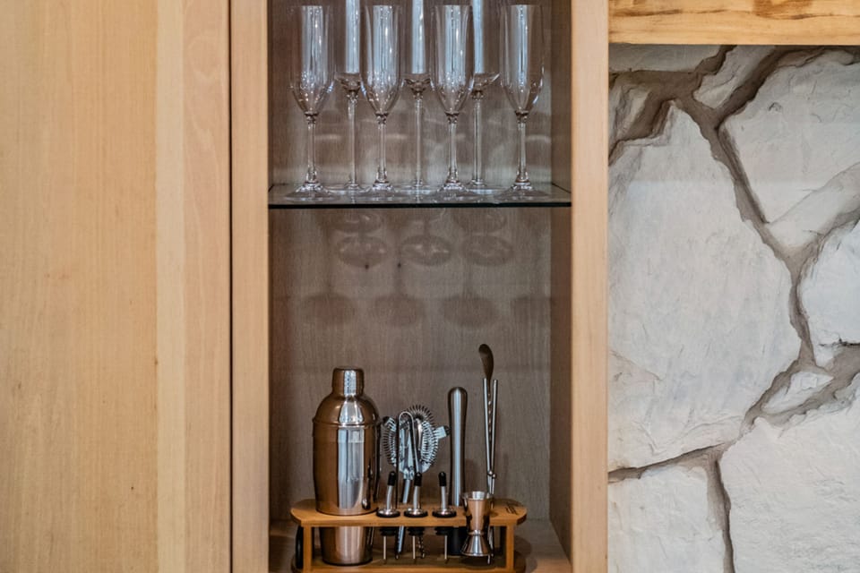 Elevate your evenings with a built-in wine and beverage bar, complete with glassware and bar tools—perfect for mixing cocktails or enjoying a relaxing glass of wine at home.