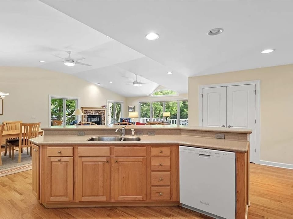 Experience open-concept living with vaulted ceilings and sunlight streaming through expansive windows.