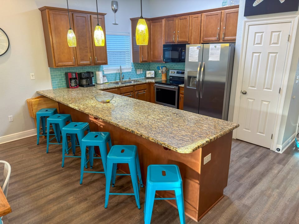 Created for entertaining, the kitchen features generous seating, modern stainless-steel appliances, and a spacious pantry for convenience.