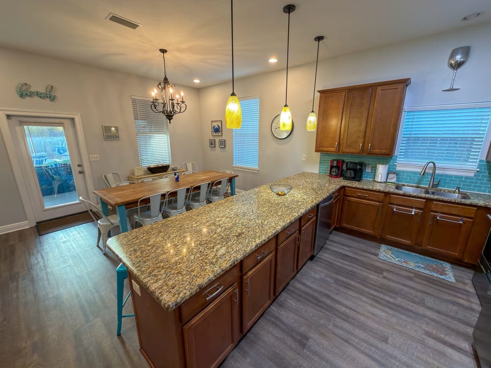 Brilliant pendant lighting, rich cabinetry, and thoughtful design details elevate the heart of the home.