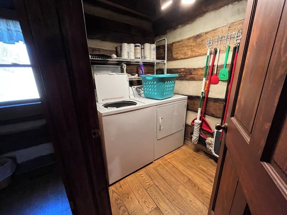 The laundry room is located next to the bathroom at the back of the kitchen. 