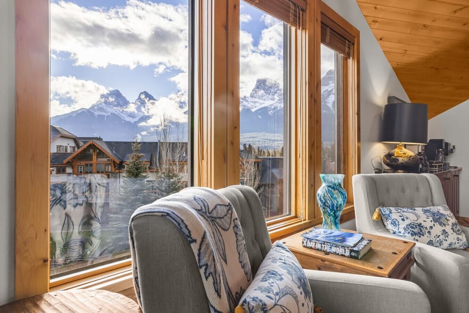 Cozy lounge + dining with windows all around—mountain vibes inside.
