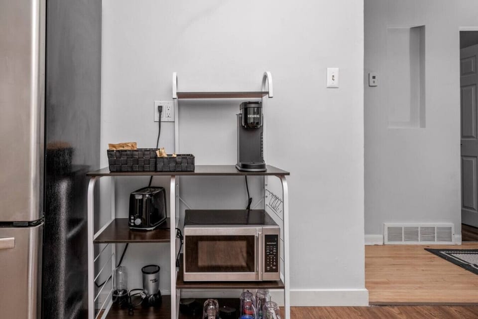 Convenient coffee station with microwave and essentials.