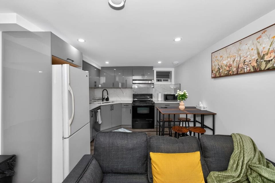 Open-concept living space with modern kitchen, dining table, new appliances, and comfortable seating