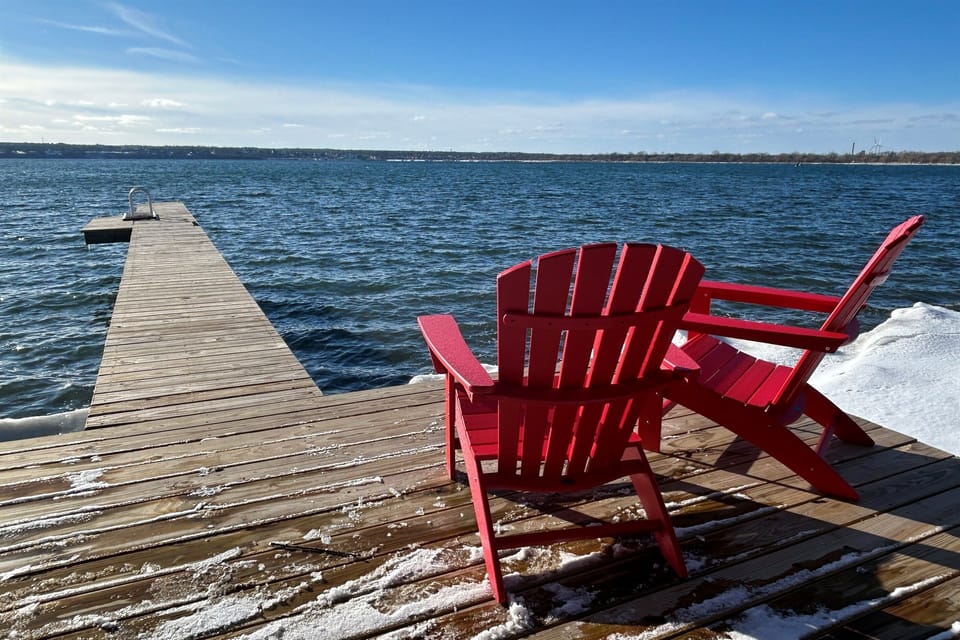 Red Adirondack chairs on the dock at winter time