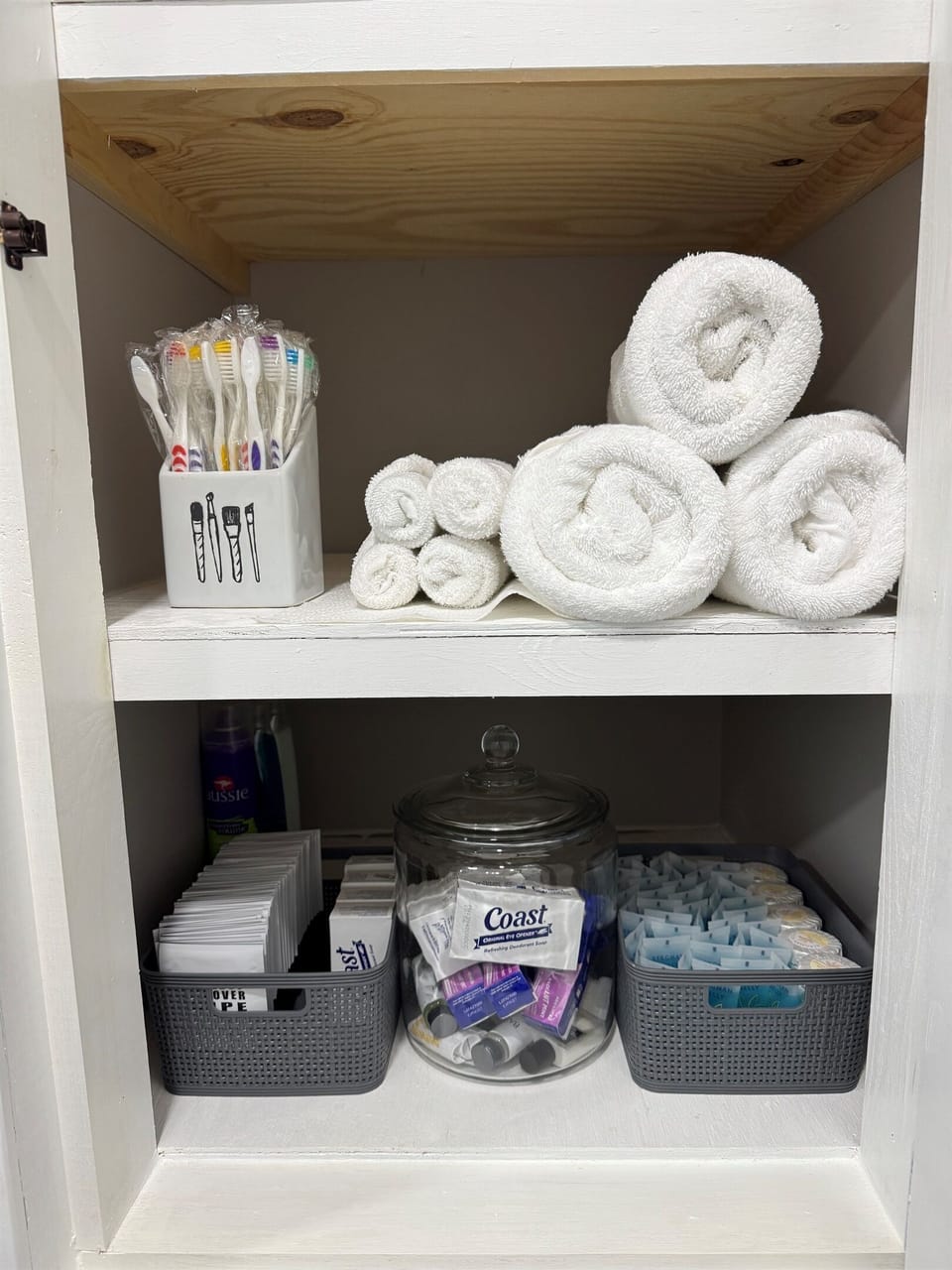 Storage shelf stocked with towels and toiletries