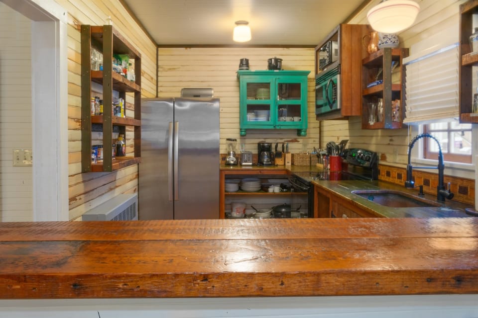 Our chef-ready kitchen is exceptionally well-provisioned with essential spices, oils, and a dedicated coffee station. Featuring stainless steel appliances and open shelving, it’s fully equipped for effortless Maine seafood feasts.