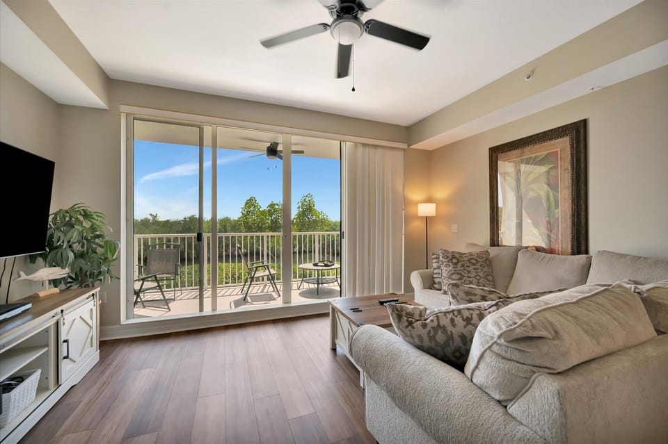 Waterfront living area with balcony access and mangrove views