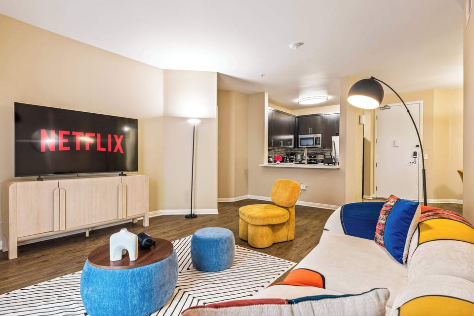 Cozy and stylish lounge area with modern decor, soft textures, and plenty of space to relax or enjoy a movie night.