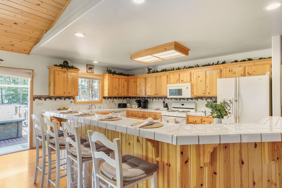Spacious kitchen with wraparound breakfast bar seating and plenty of room for group meals.