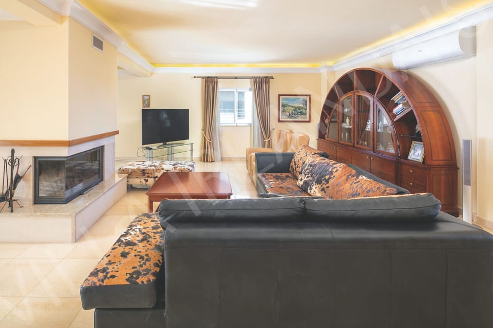 One of the lounges at Villa Irlandais, with comfortable seating around a feature fireplace and arched window.