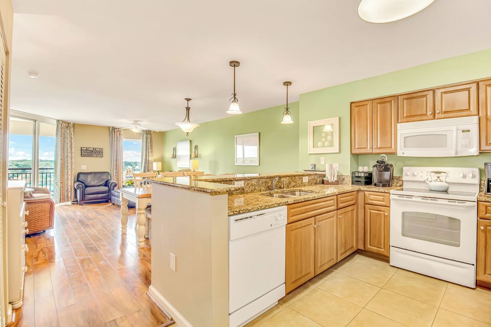 Your spacious kitchen flows into a bright living area with stunning views through floor-to-ceiling windows.