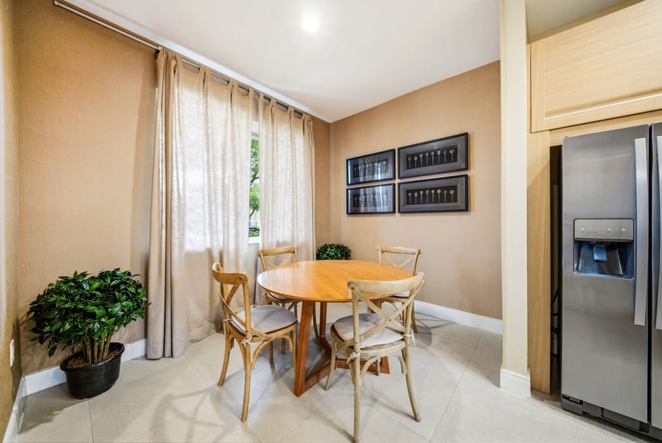 Experience relaxed dining in this cozy nook with a round wooden table and charming cross-back chairs. Soft natural light enhances the warm earth tones, creating a welcoming atmosphere for your enjoyment.