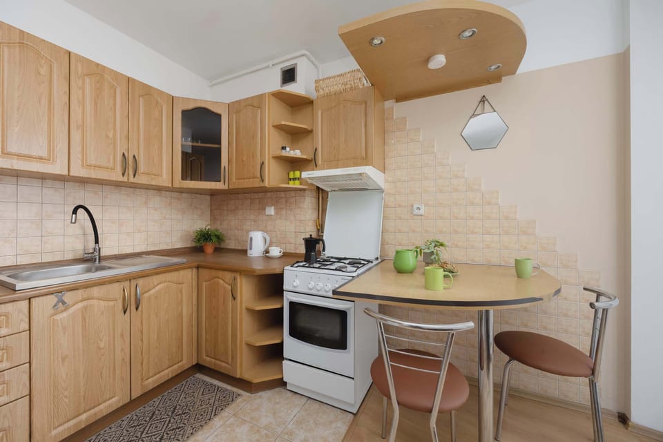 A compact dining area in the kitchen features a round wooden table with two chairs, perfect for quick meals.